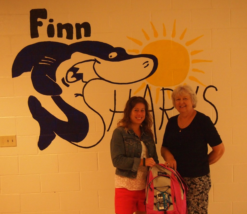 Lion Julie Thomas presents school supplies.